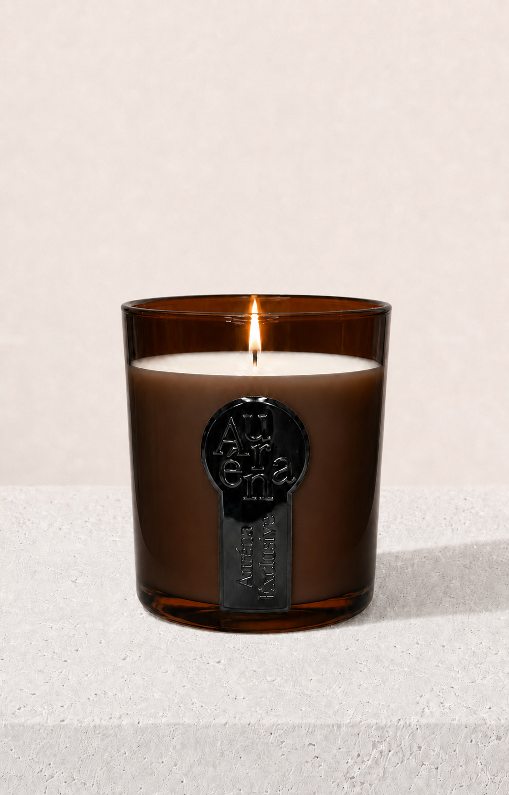 Amber gefärbte Auréna Duftkerze,die am brennen ist. Creme, Beiger eleganter Hintergrund.