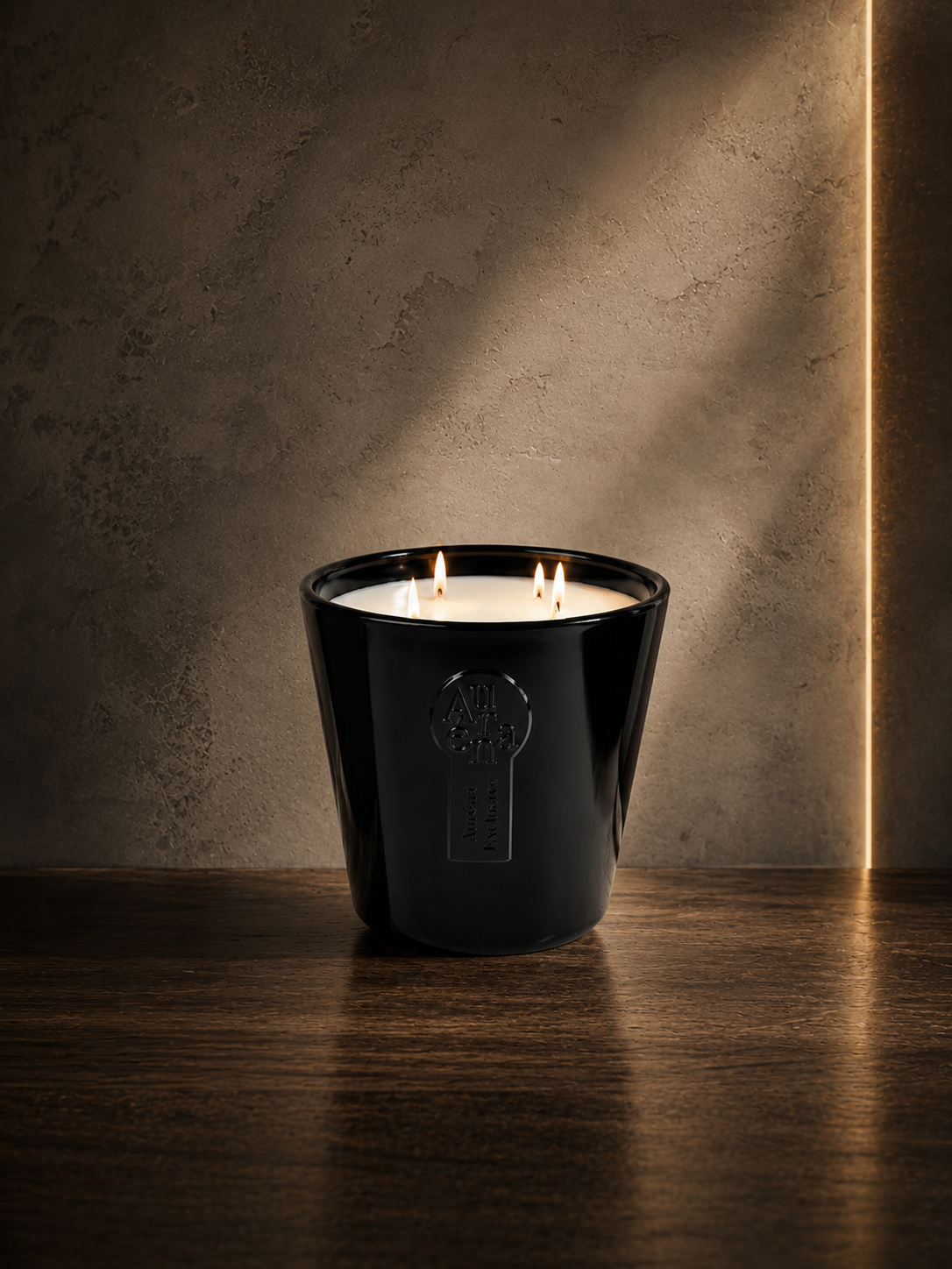 Luxuriöse schwarze Duftkerze von AURÉNA auf dunklem Holztisch vor warmer Betonwand mit cinematic Beleuchtung und brennenden Dochten.