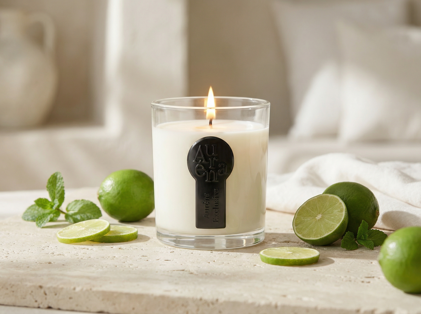 Auréna Duftkerze im klaren Glas mit brennender Flamme, umgeben von frischen Limetten und Minze in einem eleganten, hellen Interior – Duft Key Lime Peppermint