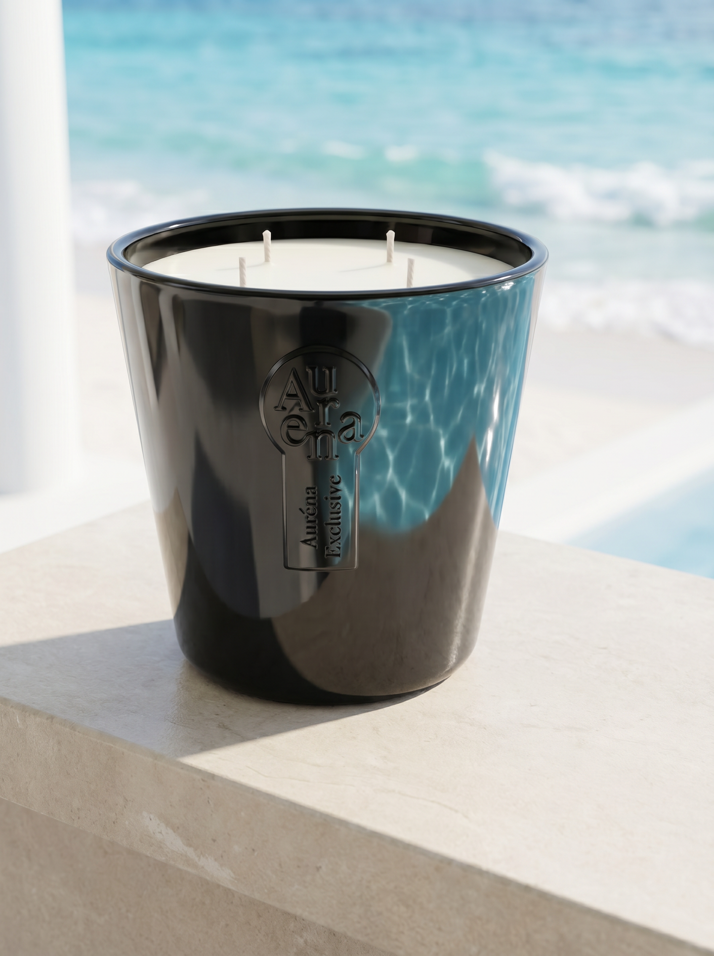 Schwarze Auréna Duftkerze mit vier Dochten auf einer hellen Steinfläche am Meer – handgegossene Premium-Kerze aus Deutschland mit frischem, maritimem Duft und luxuriöser Atmosphäre.